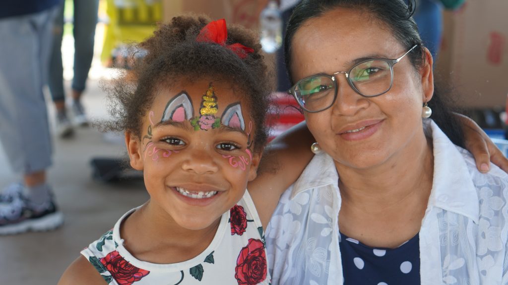 Mother and daughter with unicorn face paint smiling